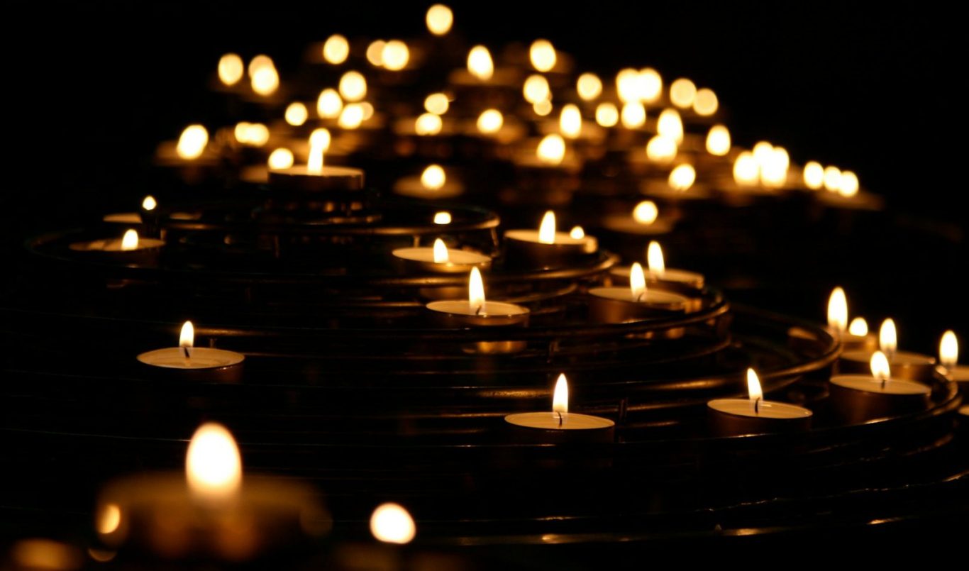 Viele flammende Kerzen in dunkler Umgebung.